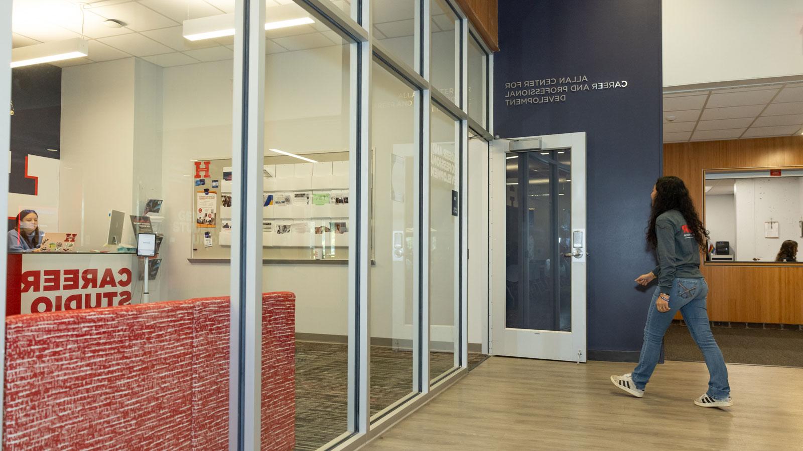 A University of Hartford student walking into the Allen Center doorway.